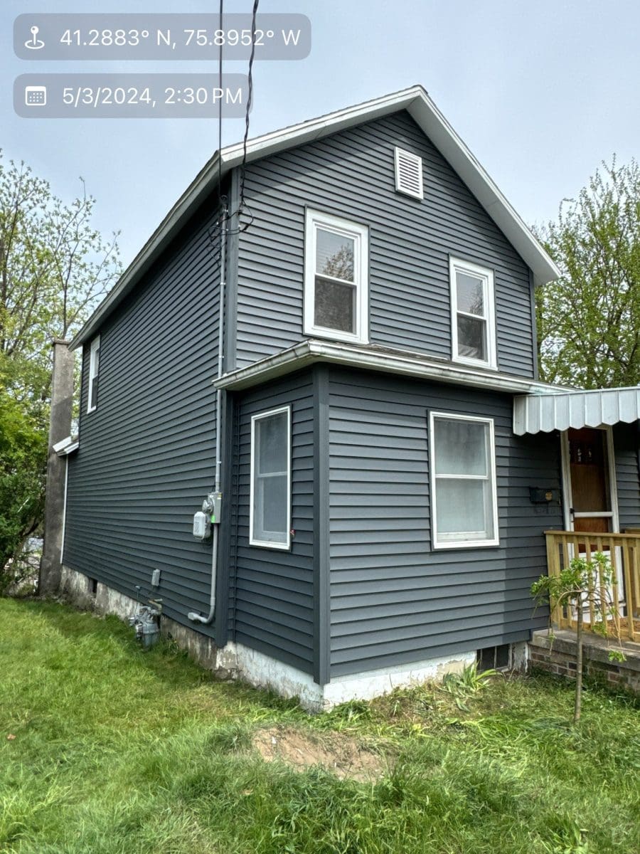 The back of a two-level home with dark gray siding.