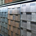 A store display of GAF designer shingles in a variety of brown, gray, and clay-colored shingles.