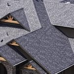 An overhead view of a large house roof made with gray GAF shingles