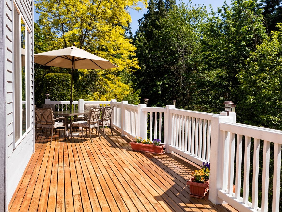 a cedar deck with white-painted railing and small planter boxes placed along its edge.