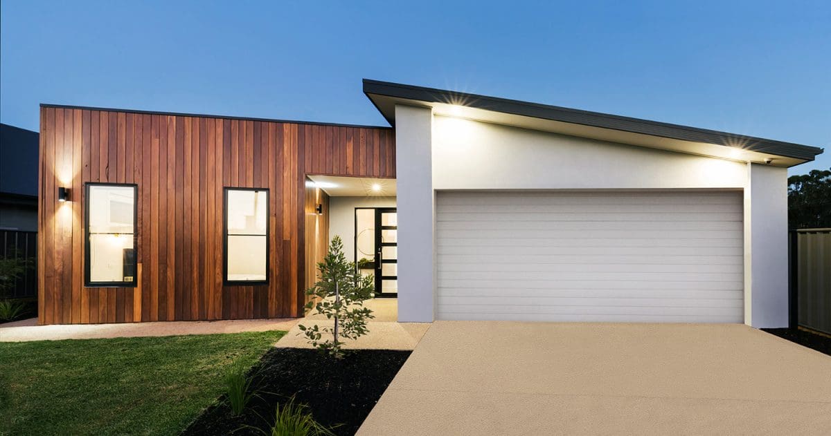 A small and modern shed-roofed home with wood panel siding and a white-paint attached garage.