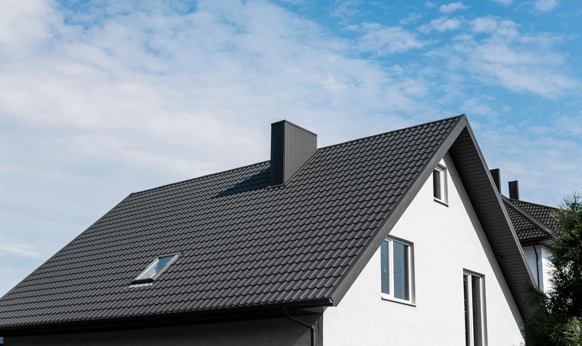 A gable-roofed home with a small skylight and chimney