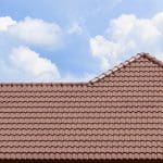 A clay tile roof with a blue sky backdrop