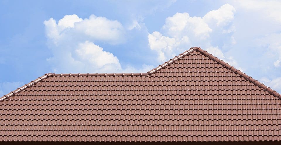 A clay tile roof with a blue sky backdrop