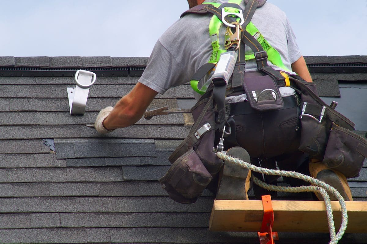 A view of a roof repair contractor doing work on a roof