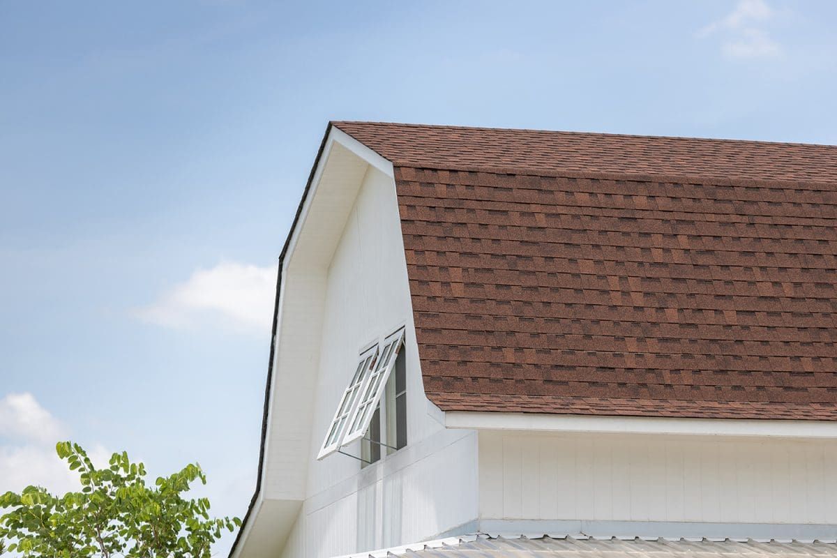 A brown shingled roof on a barn-style home