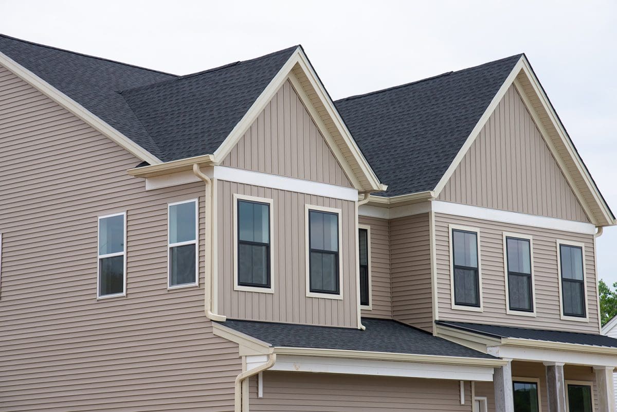 A black roof on a beige home.