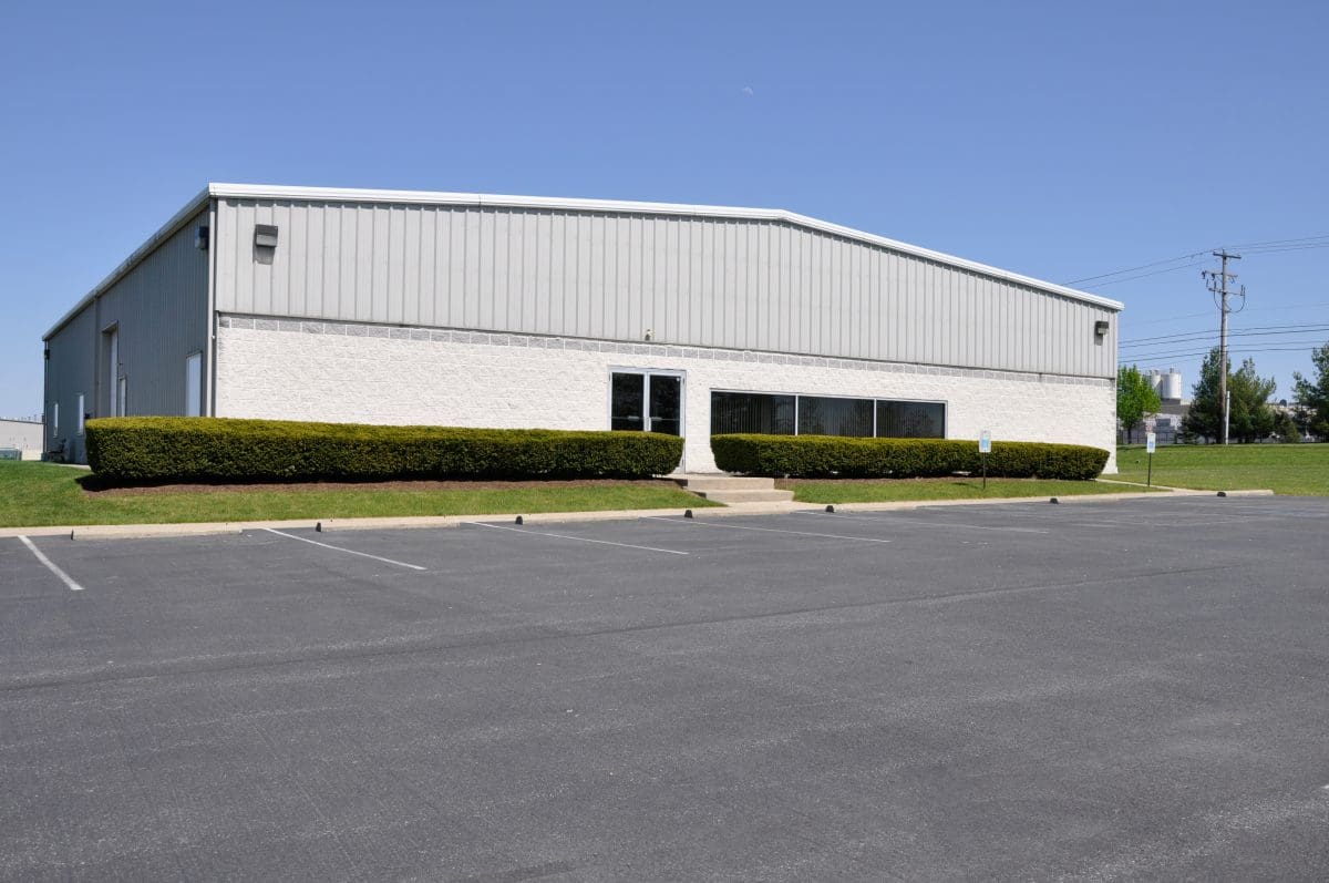 The front of a commercial building with a parking lot.